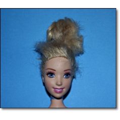 Eredeti Mattel Disney Hamupipőke szőke baba kék szemekkel és feltűzött kócos hajjal közelről fotózva