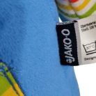 Eredeti bevarrt fekete Jako-O gyári textilcímke a kék készségfejlesztő plüss kutya oldalán közelről