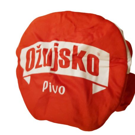 Nagy méretű fehér Ožujsko Pivo gyári logó a piros szurkolói kalap tetején közelről