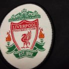 Hivatalos hímzett Liverpool FC You'll Never Walk Alone klubcímer közelről a nadrágon