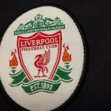 Hivatalos hímzett Liverpool FC You'll Never Walk Alone klubcímer közelről a nadrágon
